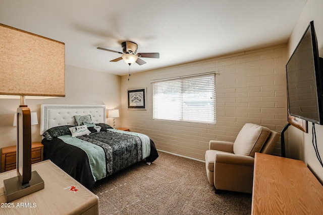 carpeted bedroom with ceiling fan and brick wall