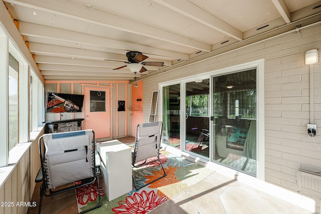 sunroom featuring ceiling fan and beamed ceiling