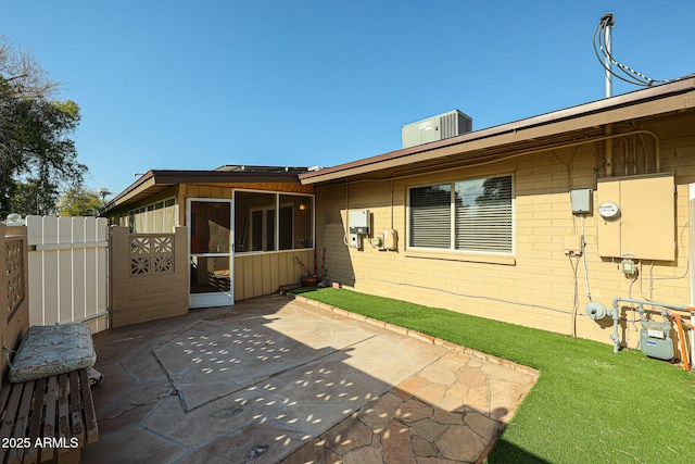 rear view of property featuring a sunroom, cooling unit, and a patio