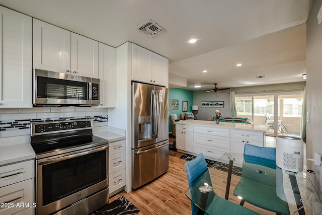 kitchen featuring white cabinets, ceiling fan, backsplash, and appliances with stainless steel finishes