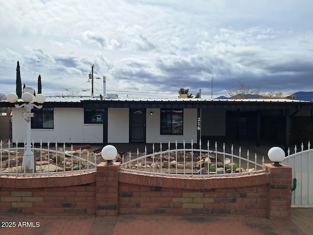 view of front of home with metal roof and fence