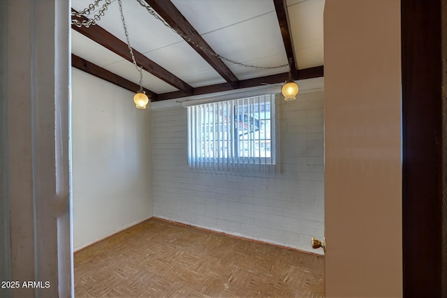 spare room featuring beamed ceiling