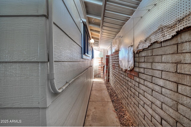 hall featuring brick wall