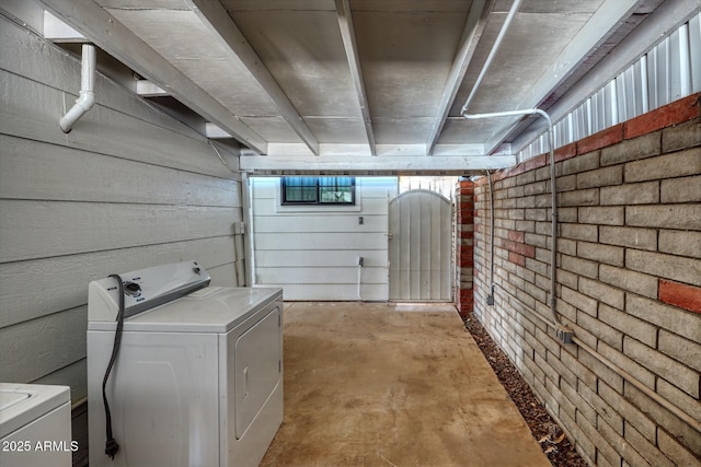 basement featuring washer / clothes dryer and brick wall