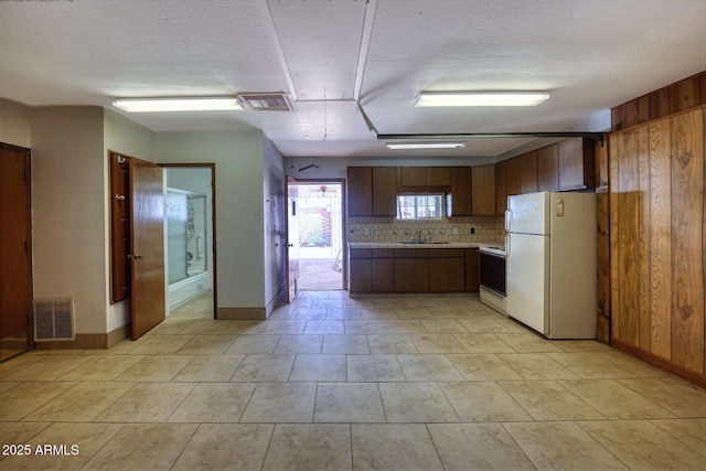 kitchen featuring visible vents, white appliances, light countertops, and decorative backsplash