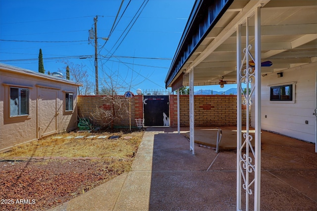 view of yard with a patio area, a gate, fence, and an outbuilding