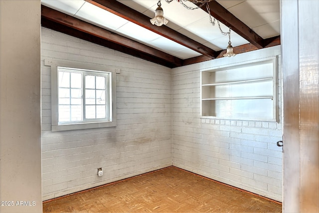 unfurnished room with beamed ceiling