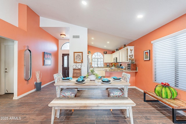 dining area with lofted ceiling, baseboards, visible vents, and wood tiled floor