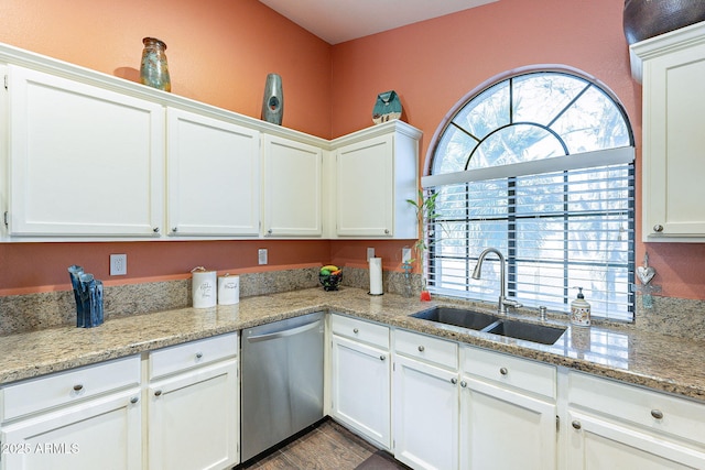 kitchen featuring stainless steel dishwasher, a sink, and white cabinetry