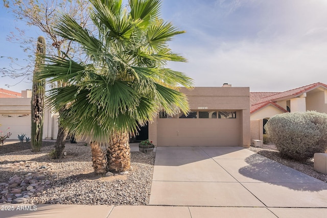 view of front of property with a garage, concrete driveway, and stucco siding