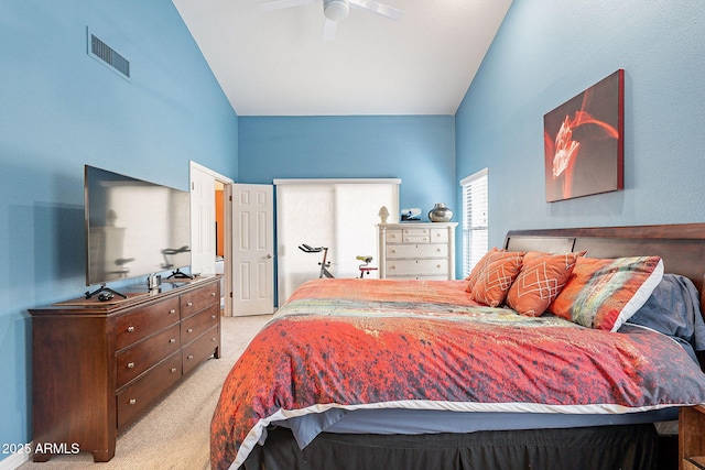 carpeted bedroom featuring lofted ceiling, visible vents, and a ceiling fan