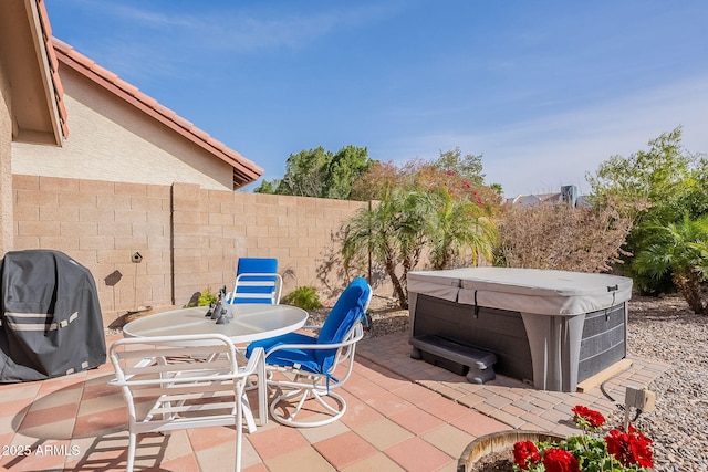 view of patio / terrace with a hot tub, fence, and area for grilling