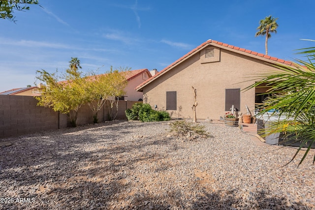 back of house featuring a fenced backyard and stucco siding