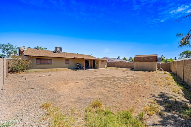 back of property featuring a fenced backyard, a shed, and an outbuilding
