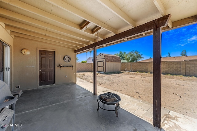 view of patio featuring an outdoor structure, a shed, and a fenced backyard
