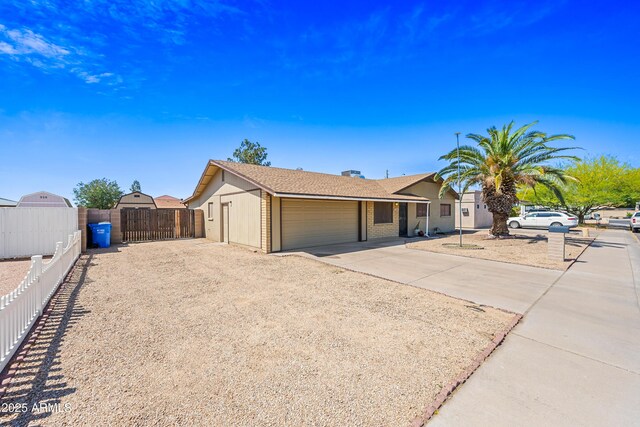 ranch-style house with a garage, fence, a gate, and driveway