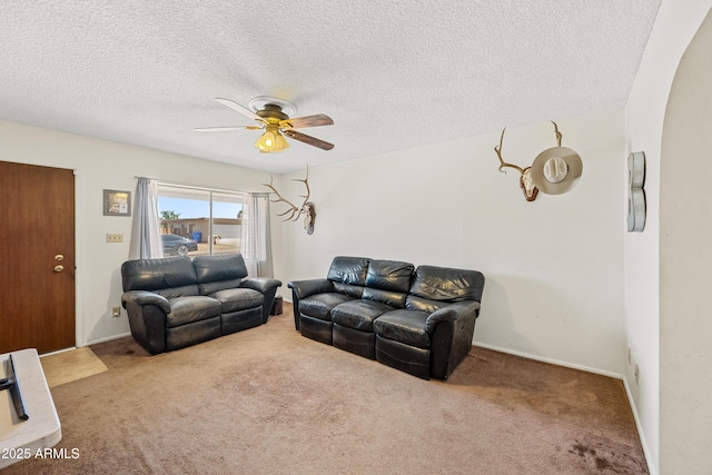 carpeted living area featuring a ceiling fan and a textured ceiling