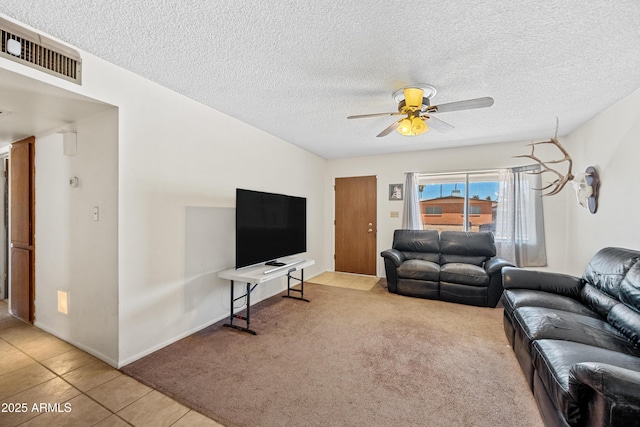 tiled living room featuring carpet, a ceiling fan, visible vents, and a textured ceiling