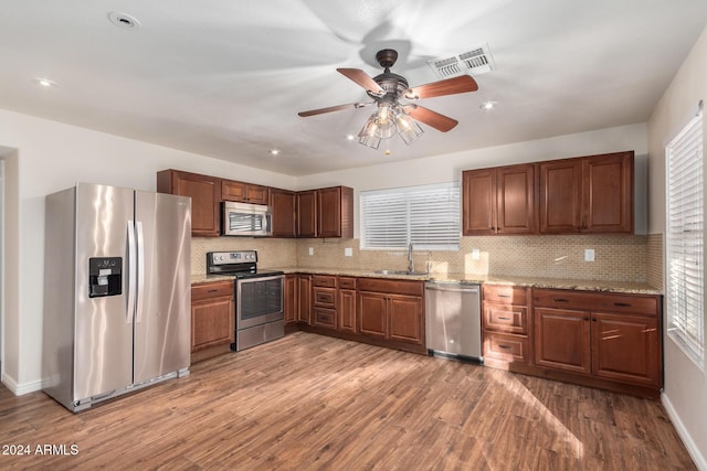8143 E Obispo Ave, Mesa, AZ 85212 - kitchen featuring stainless steel appliances, a sink, a ceiling fan, wood finished floors, and decorative backsplash