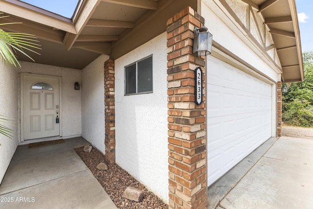 2633 E Garnet Ave, Mesa, AZ 85204 - doorway to property featuring stucco siding, a garage, and brick siding