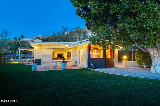 rear view of house featuring a patio area and a yard