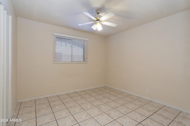 tiled spare room featuring ceiling fan and a textured ceiling