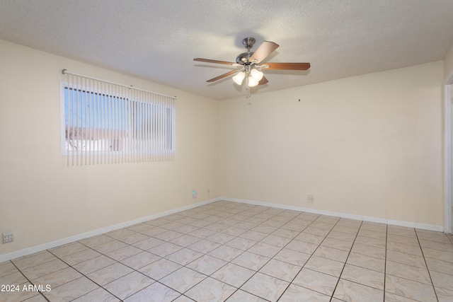 tiled spare room with a textured ceiling and ceiling fan