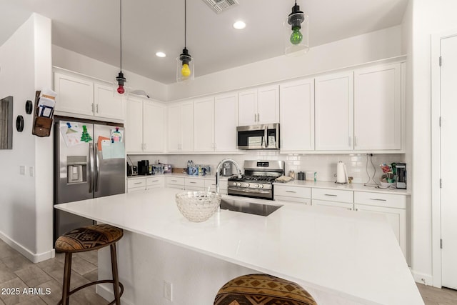 3832 W Mcneil St, Laveen, AZ 85339 - kitchen featuring appliances with stainless steel finishes, white cabinets, a kitchen breakfast bar, baseboards, and pendant lighting
