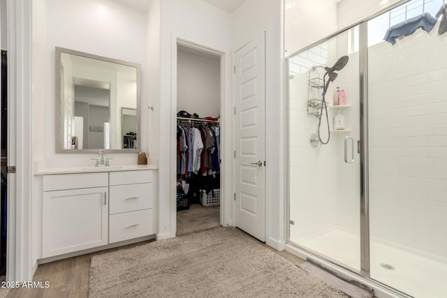 3832 W Mcneil St, Laveen, AZ 85339 - bathroom with a shower stall, vanity, a walk in closet, and wood finished floors