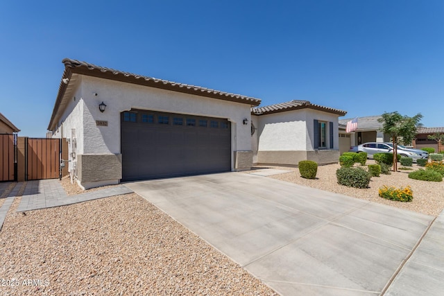 3832 W Mcneil St, Laveen, AZ 85339 - mediterranean / spanish home with stucco siding, a gate, an attached garage, concrete driveway, and a tile roof
