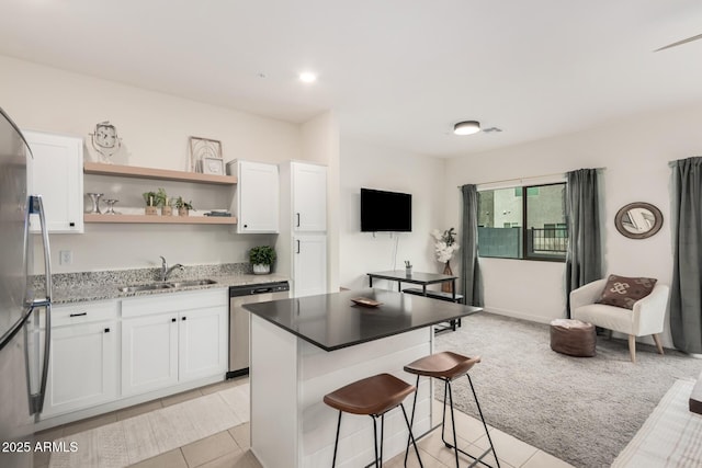 2256 W Laurie Ln, Phoenix, AZ 85021 - kitchen with a sink, appliances with stainless steel finishes, white cabinets, a kitchen breakfast bar, and recessed lighting