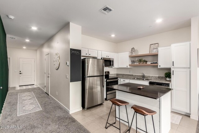 2256 W Laurie Ln, Phoenix, AZ 85021 - kitchen with stainless steel appliances, open shelves, white cabinets, a sink, and a breakfast bar area