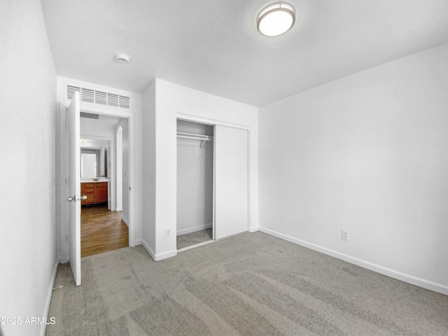 unfurnished bedroom featuring carpet flooring and a closet