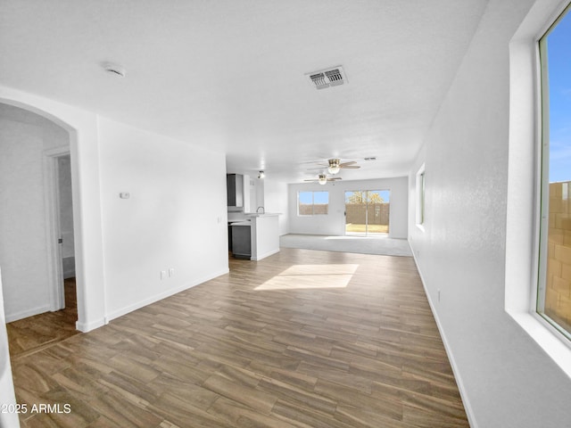 unfurnished living room featuring hardwood / wood-style flooring and ceiling fan