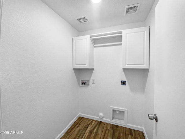 laundry room with dark hardwood / wood-style floors, cabinets, hookup for an electric dryer, and hookup for a washing machine