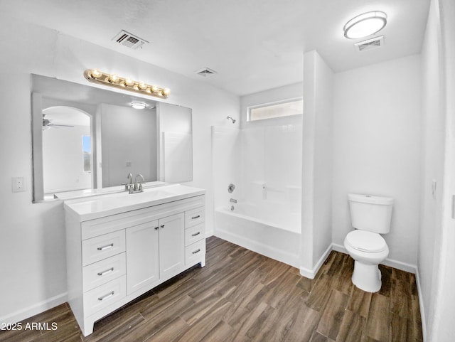 full bathroom with bathtub / shower combination, wood-type flooring, toilet, and vanity