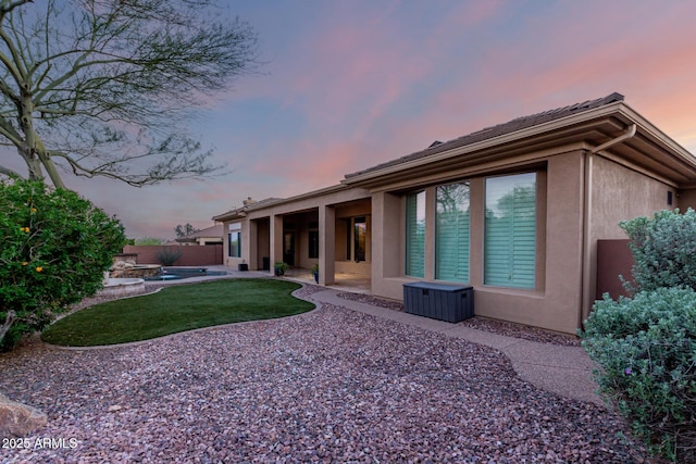 41715 N River Bend Rd, Phoenix, AZ 85086 - back of property at dusk with stucco siding, fence, and a patio