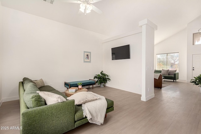 living room with decorative columns, visible vents, baseboards, ceiling fan, and wood finished floors