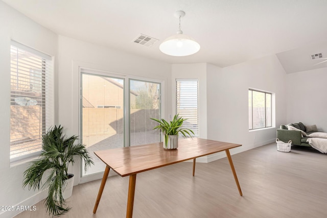 office featuring lofted ceiling, light wood finished floors, visible vents, and baseboards