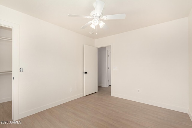 interior space with a closet, light wood-style flooring, and baseboards