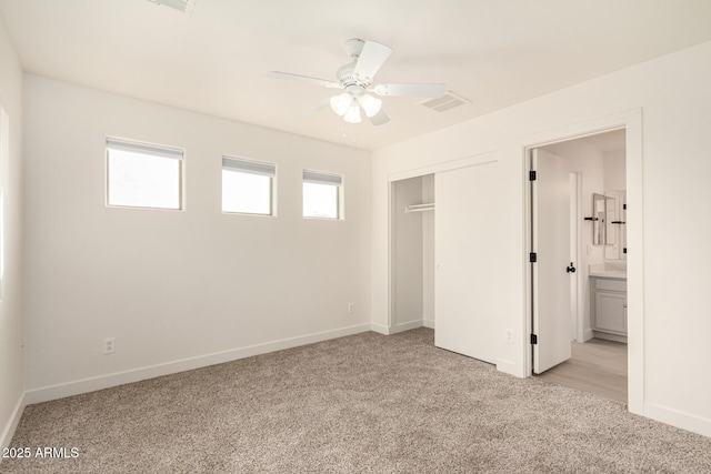 unfurnished bedroom with baseboards, a closet, visible vents, and light colored carpet