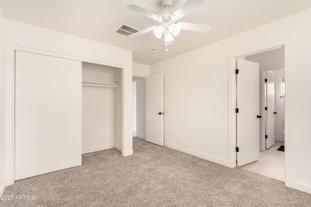 unfurnished bedroom with light carpet, ceiling fan, a closet, and visible vents