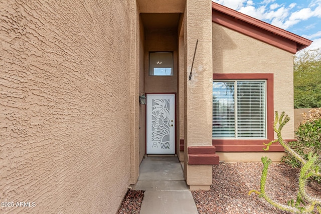 doorway to property featuring stucco siding