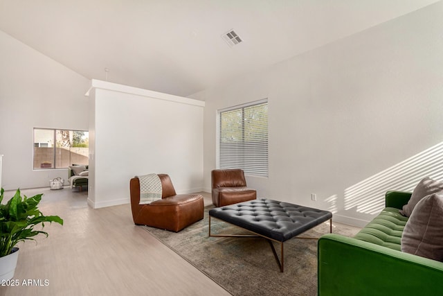 living room with visible vents, light wood-style flooring, and baseboards