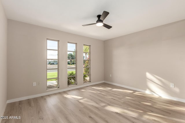 unfurnished room with wood finished floors, baseboards, and a ceiling fan