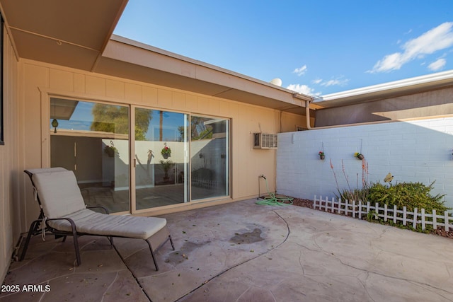 view of patio / terrace with fence and a wall mounted air conditioner