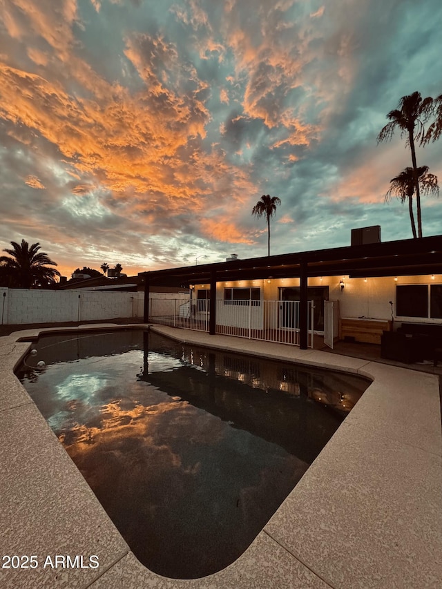 pool at dusk featuring a patio area