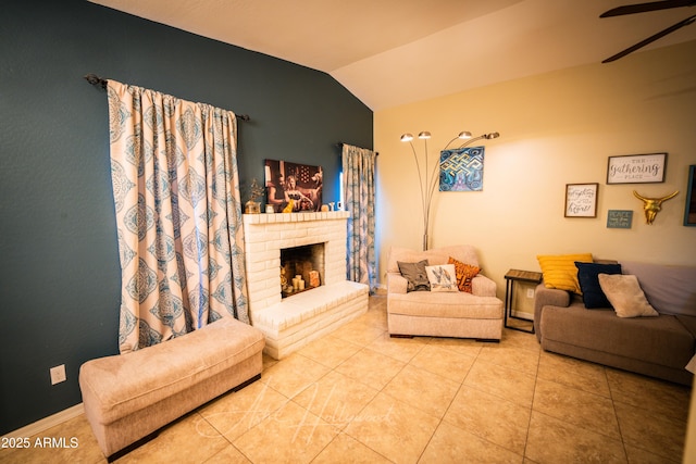 living room with light tile patterned flooring, lofted ceiling, ceiling fan, and a brick fireplace