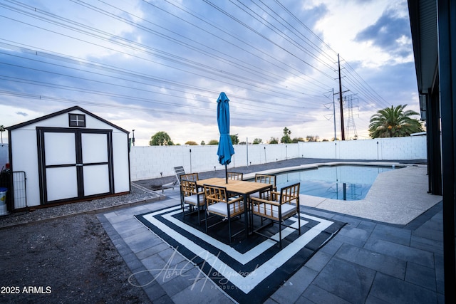 view of swimming pool with a shed and a patio