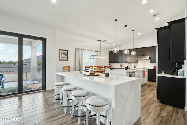 kitchen with dishwasher, a large island, pendant lighting, and a kitchen bar